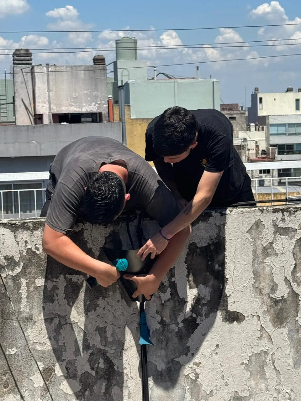 Dos técnicos de Vámonos Pest trabajando en la azotea de un edificio