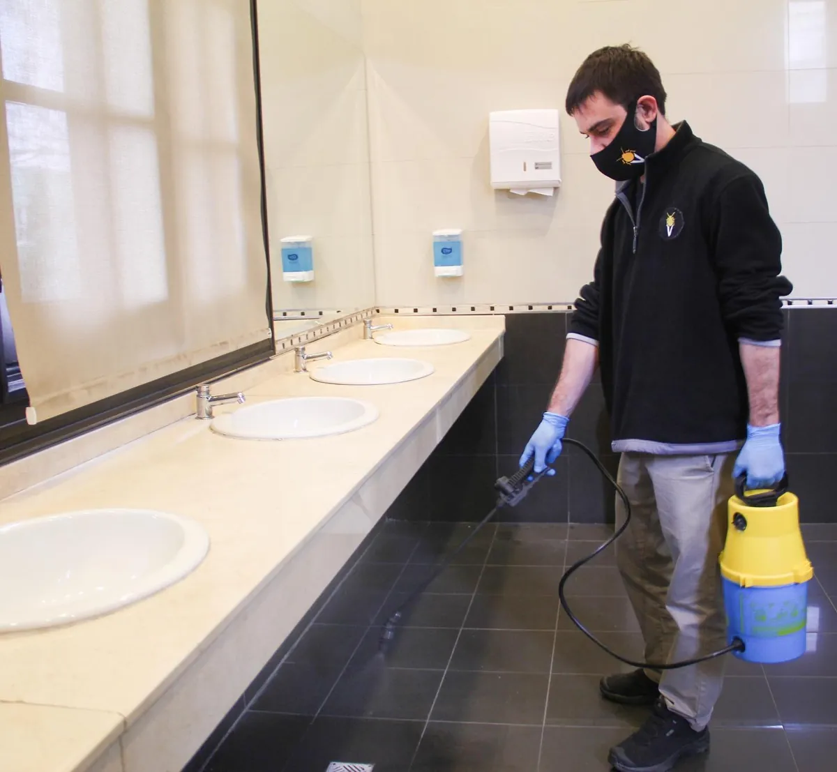 Técnico de Vámonos Pest con la campera de la empresa trabajando en un comercio